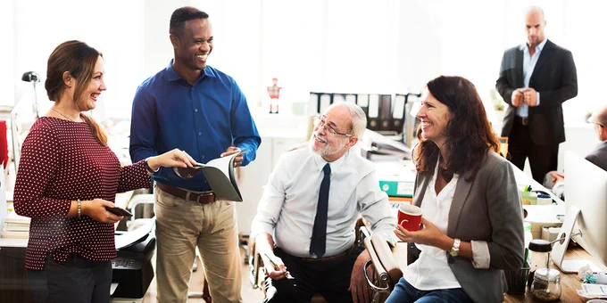 Diverse group of happy business team working together in an office setting.