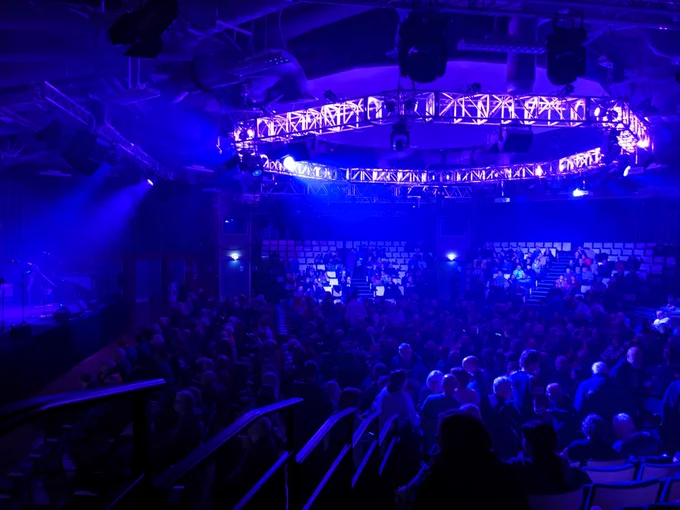 Interior of The Octagon in Sheffield as the crowd arrive, lit in blue.