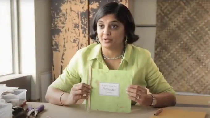 Book artist Sushmita Mazumdar holding a family stories book she created in her how-to video