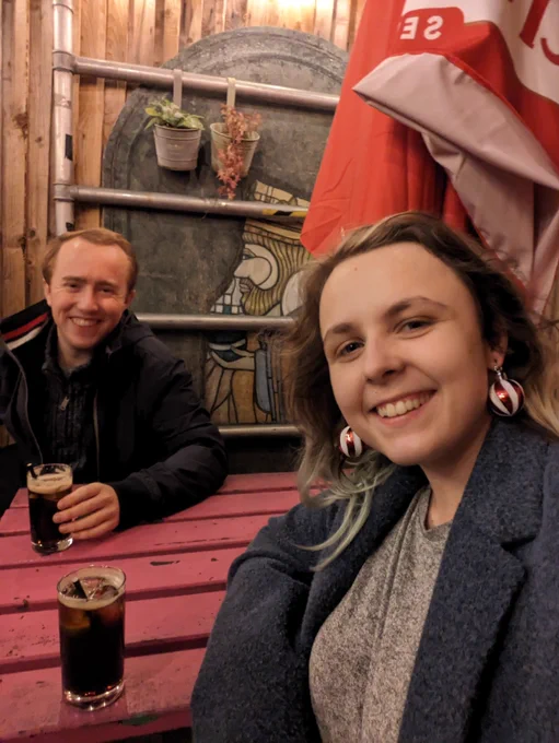 Amy and Josh are having a drink. Amy has bauble earrings.