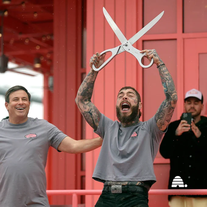 Raising Cane’s founder Todd Graves and Post Malone celebrate after cutting the ribbon during the grand opening of a Raising Cane’s Restaurant, designed by the singer, in Midvale on Thursday, April 13, 2023. | By Kristin Murphy, Deseret News