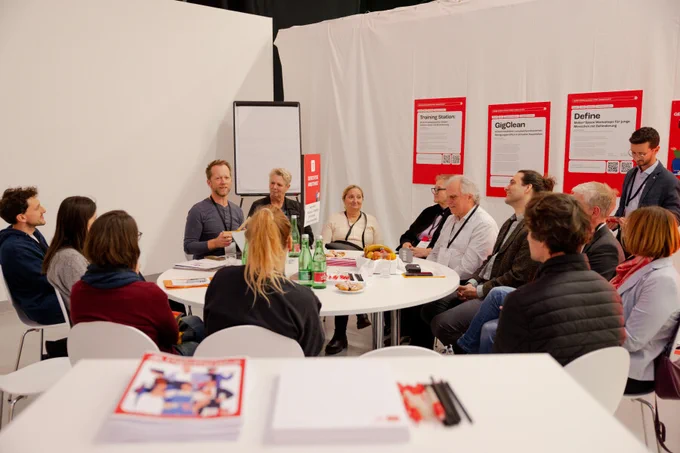 Die Gruppe "Reise in eine gerechtere Arbeitswelt" sitzen und besprechen die jeweiligen Themen.
