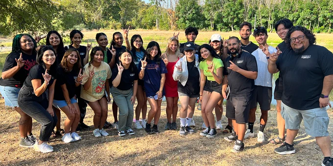 Image of IIE students doing a "hook 'em" 