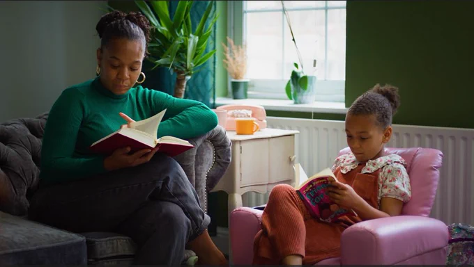Photo of a woman and a young girl reading together.