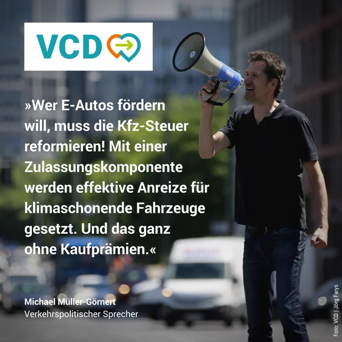 Ein Foto von Michael Müller-Görnert, dem verkehrspolitischen Sprecher der VCD, mit einem Megafon auf der Straße. Zitat im Bild: " Wer E-Autos fördern will, muss die Kfz-Steuer reformieren! Mit einer Zulassungskomponente werden effektive Anreize für klimaschonende Fahrzeuge gesetzt. Und das ganz ohne Kaufprämien."