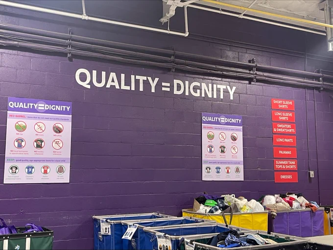 Sign on the wall at Cradles to Crayons that says Quality = Dignity 