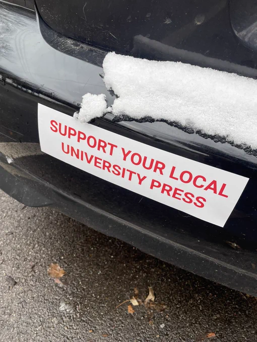 SUPPORT YOUR LOCAL
UNIVERSITY PRESS bumper sticker on a black car with snow.
