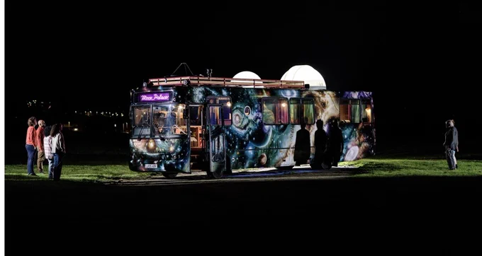 Moon Palace bus in a field at night