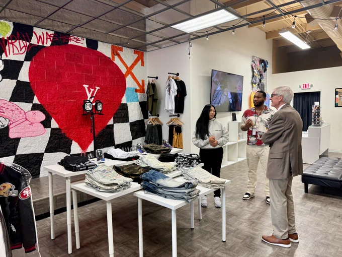 Gov. Evers talks to two small business owners while viewing merchandise.