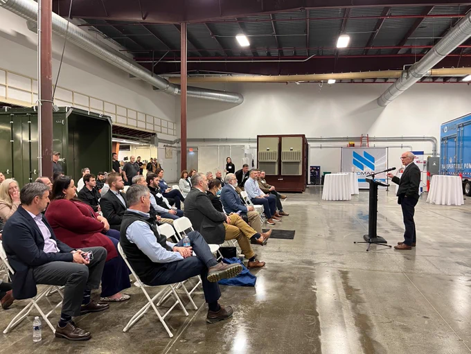 Photo of Peter speaking to an audience at a podium. 