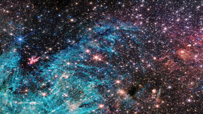 Image: starbursts on a dark background with blue and pink streaks and details; a new photograph from NASA's James Webb Space Telescope reveals never-before-seen details at the centre of the Milky Way and more about the "extreme cosmic environment" in which stars are formed 💫