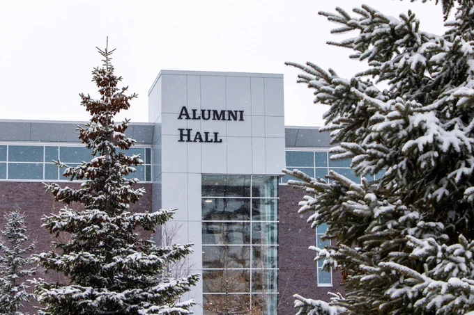Photo of alumni hall at Carleton University with snow covered trees 