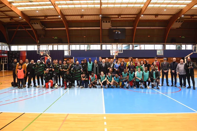 Grande photo de famille sur le terrain de football à 7 du complexe sportif Géo-André avec Amélie Oudéa-Castéra, les organisateurs du trophée du vivre ensemble et tous les participants du tournoi de football.