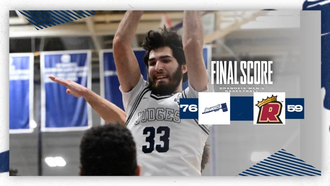 TEXT: FINAL SCORE: Brandeis Men's Basketball 76, Regis 59
IMAGE: Aedan Using grabbing a rebound during a basketball game 