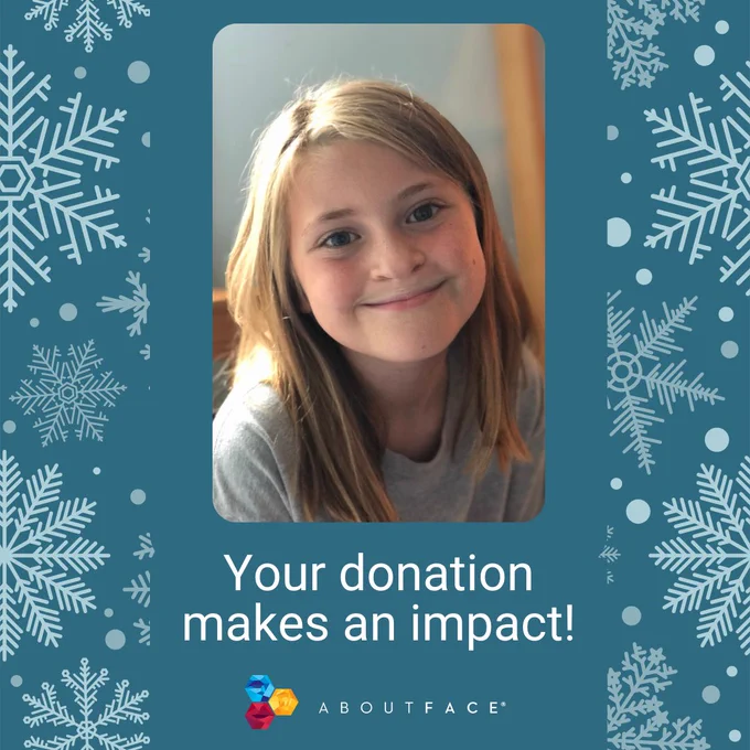 blue background with white snowflakes. There is a photo of a young girl with a facial difference in the middle with white text below that reads "your donation makes an impact" with the AboutFace logo below. 