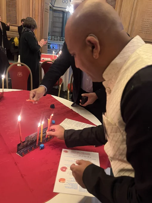 Dharmesh Mistry, Bradford Hindu Council and West Yorkshire Police, lighting a Chanukah candle at Leeds event.