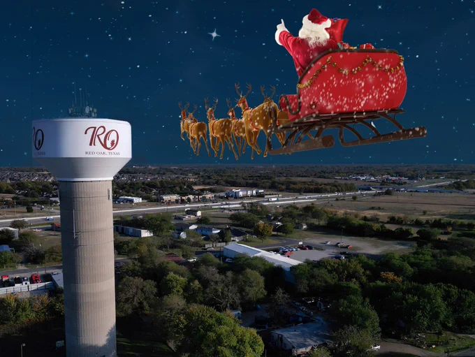Image of Red Oak Water Tower with Santa, reindeer, and sleigh flying through the air towards Red Oak.