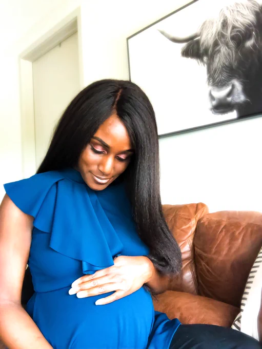 Pregnant Black woman with long hair in blue blouse smiling. The Leasing Masters’ Founder
