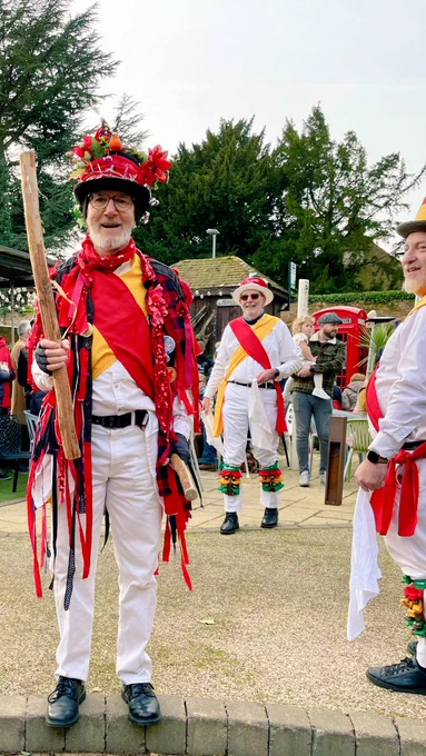 3 morris men smiling in a pub garden.