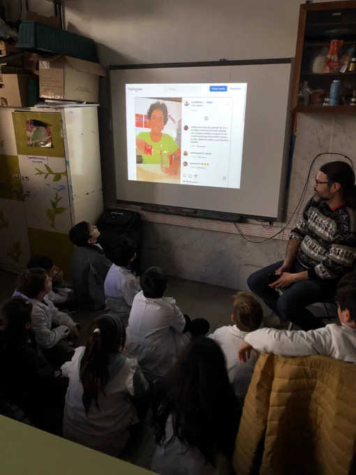Niños y niñas de cuarto grado viendo el video de Cecilia en una pantalla.