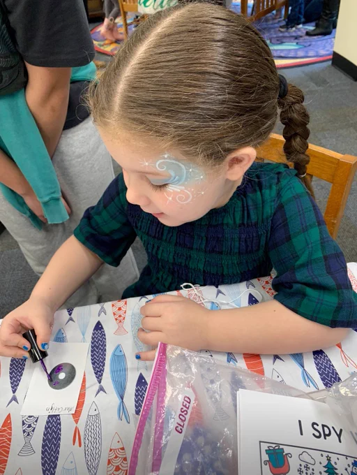 Girl with facepaint doing crafts