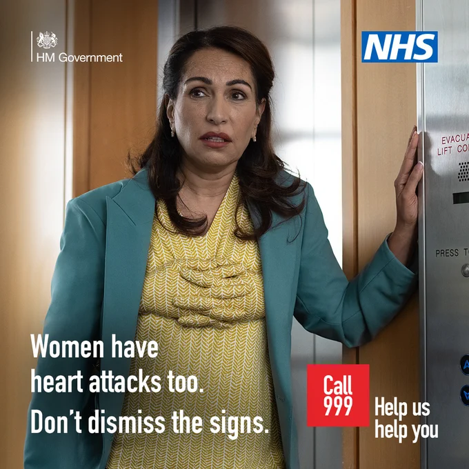 A woman in a yellow dress and green coat with hands around her chest. The woman looks panicked. Text reads: "Don't dismiss the early signs of a heart attack. Call 999 Help Us Help You.
