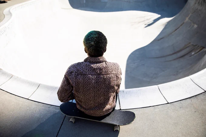 Skateboarder at an empty pool skatepark.