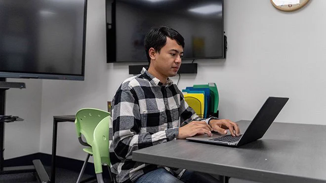 Kyle Villella ’23, a full-time Spanish teacher and M.A. candidate in Special Education at Roger Williams University, logs in to Mursion in the Education Department's model classroom.