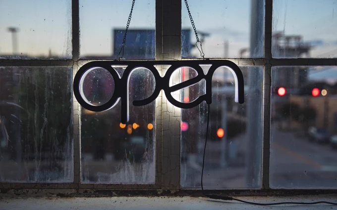 "open" neon sign in a window