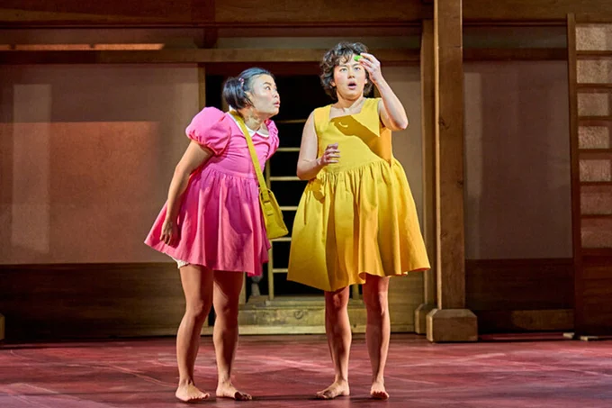 A photo showing two performers in brightly coloured outfits 