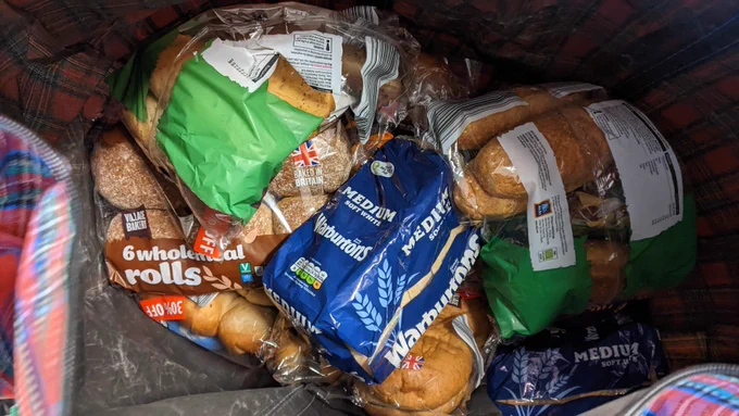 A close-up of donated surplus bread and rolls in packaging.