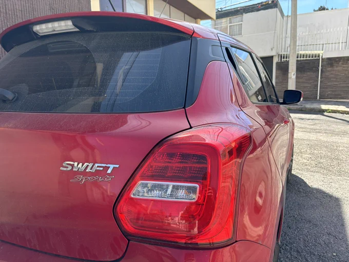 Photo of a red Swift Sport manufactured by Suzuki.