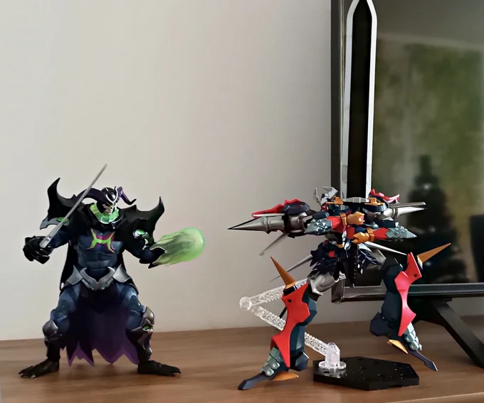 A figure of a powered-up Skeletor (from He-Man) is ready to attack Dygenguar, who assumes a fighting stance wielding his sword Zankantou in its expanded form.