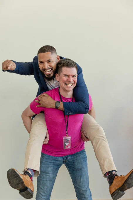 Michael Liendo riding on Richard’s back while pointing forward with a fist.
