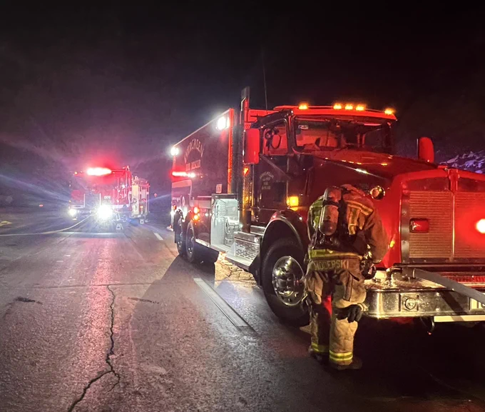 A firefighter stands by a water tender