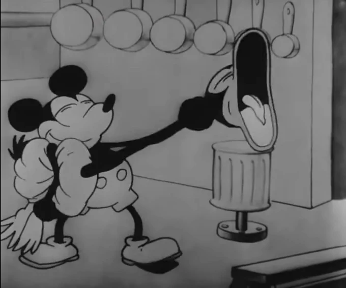 Mickey Mouse throttling a bird and smiling in Steamboat Willie