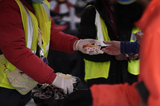 A photo of someone handing a waffle to a Resolution Run participant.