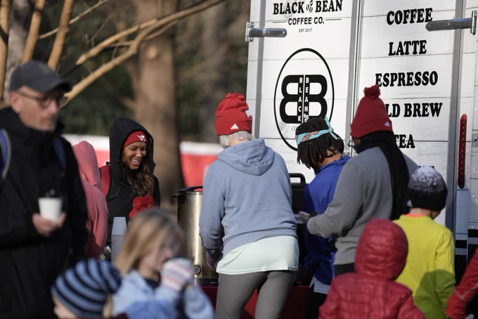 A group of Resolution Run participants fill up cups of coffee from Black Bean Coffee Co.