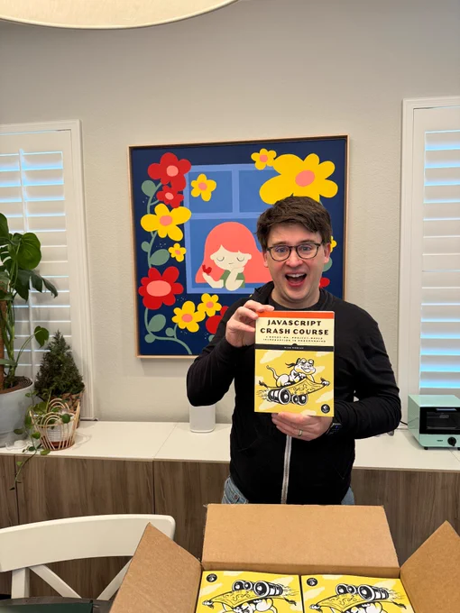 Me holding a copy of JavaScript Crash Course