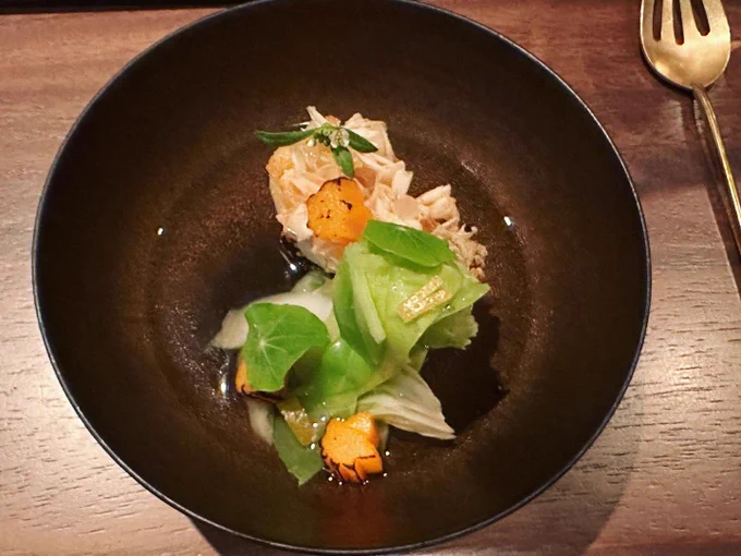A bowl with fish slices and cabbage slices in a broth