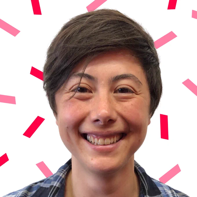 Headshot of Ailin Conant smiling, she has short brown hair and wears a blue checked shirt. Red and pink confetti surround her. 