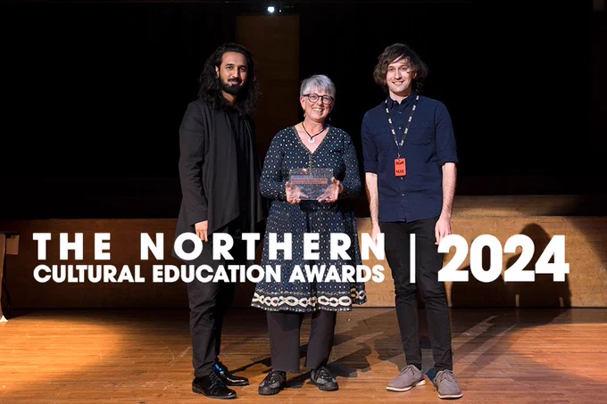 Three people on stage accepting an award. The Northern Cultural Education Awards 2024 logo.
