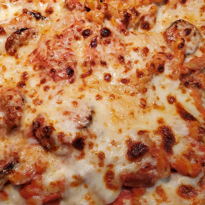 Melted/toasted mozzarella cheese, covering pasta.