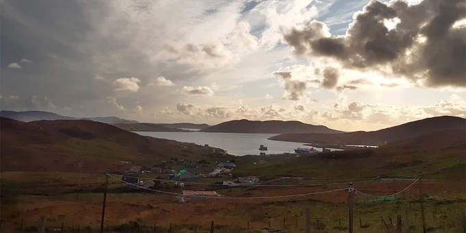 View from the school windows showing the hills and water on a sunny-cloudy day on the Isle of Barra