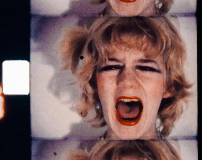 The artist’s face is seen in a close crop on film strip as she screams continually.
