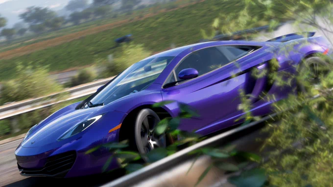 A 2012 McLaren MP4-12C finished in my interpretation of Velvet Purple (I haven't found a good picture to replicate this paint) drifting near the Quebrada Trailblazer start gate in Forza Horizon 5.