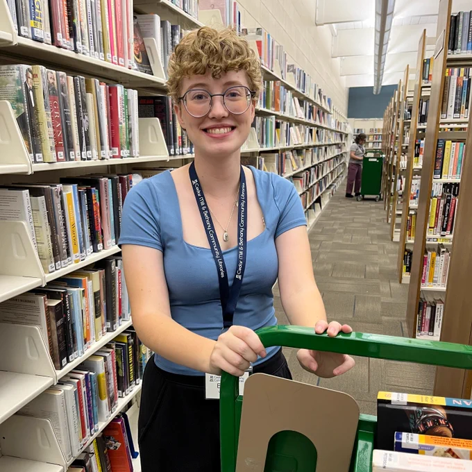 library volunteer pushing cart