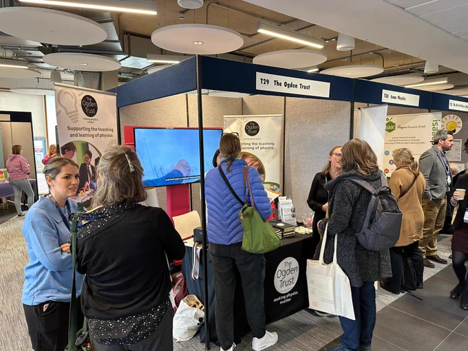 People in conversation in front of the Ogden conference stand