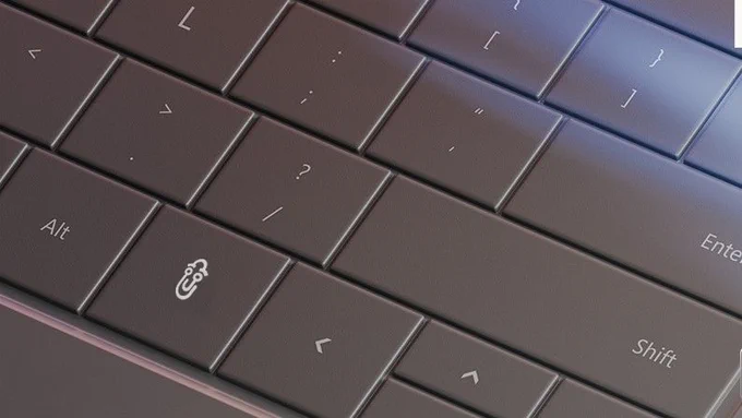 A photograph of a computer keyboard with the windows/copilot key replaced with a picture of clippy the paperclip.