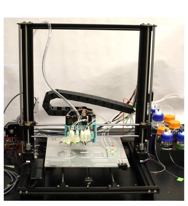 A photo of the Electrolab, which has a metal arc with tubing coming off of it and a robotic arm off of the side of it that can be used to place things on a metal plate